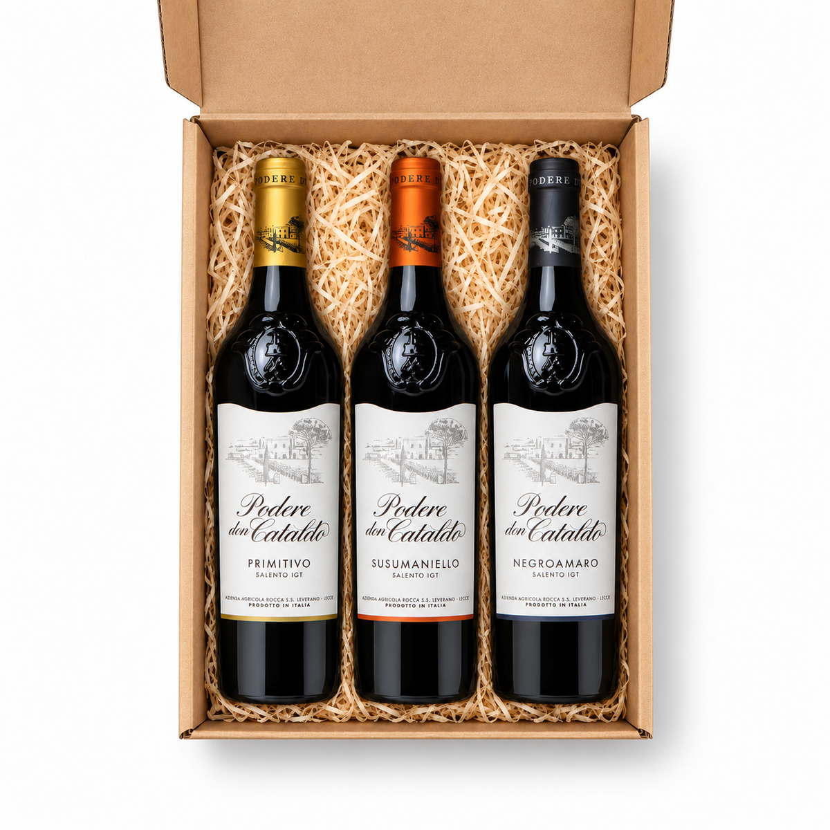 Draufsicht auf Podere Don Cataldo Rossi del Salento: Primitivo, Susumaniello und Negroamaro als drei gerade angeordnete 0,75-Liter-Flaschen in der offenen Geschenkbox.